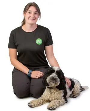 Trainer Jen with cockapoo laying beside her