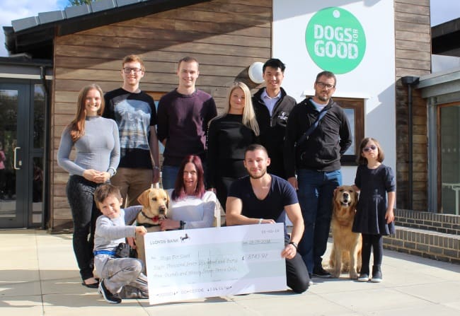 Group of staff from Willmott Dixon with two assistance dogs and their owners
