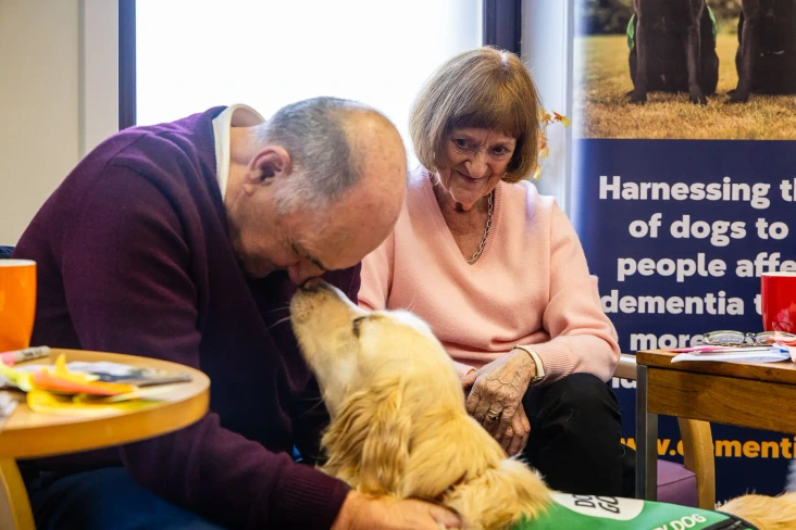 Golden Retriever Man Woman Sitting Smiling Workshop