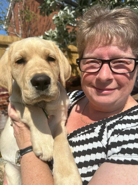 Puppy Socialiser Charlotte holding yellow labrador puppy Hazel