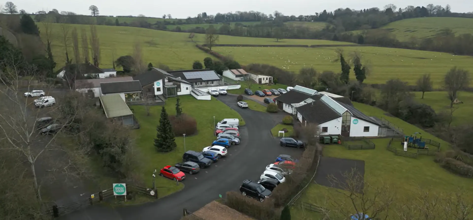 Aerial view of the Dogs for Good training centre in Banbury. Several buildings, parked cars can be seen in the foreground with fields and trees in the background