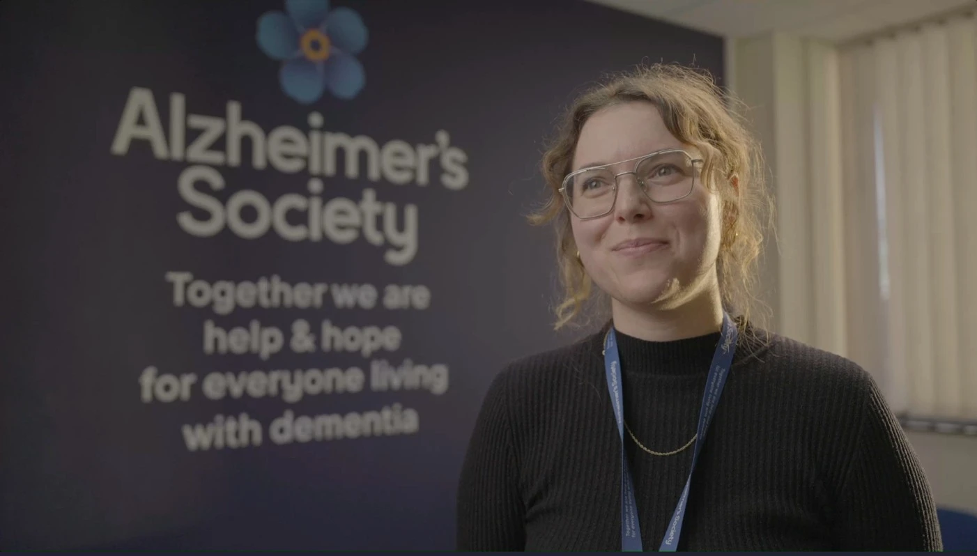 Headshot Of Sophia Simlat In Front Of Alzheimer's Society Banner