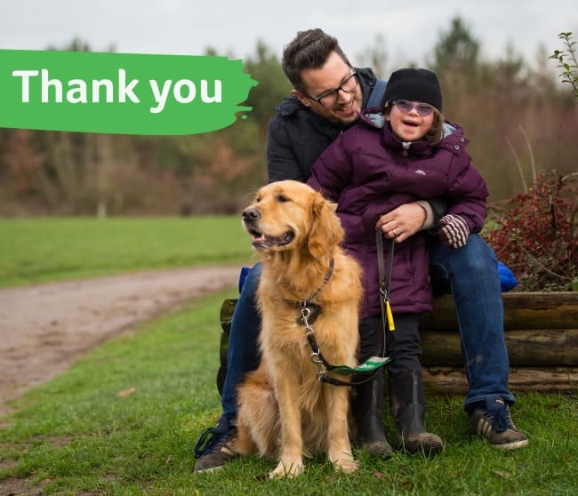 Milli, her dad and assistance dog Emma with a thank you message