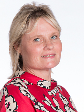 Headshot of Sarah. She has short blonde hair and a red patterned blouse on. 