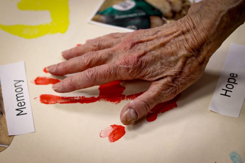 A hand making a handprint with red paint
